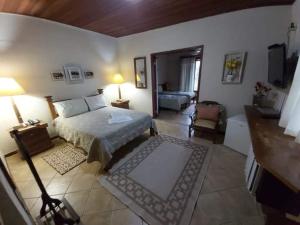 Pousada Mar a Mar في بوزيوس: غرفة نوم مع سرير وغرفة معيشة