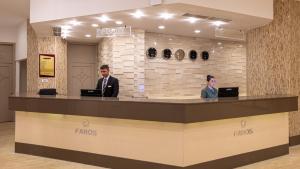 two people standing at a reception counter in a lobby at Faros Premium Beach in Marmaris