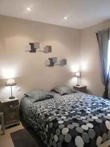 a bedroom with a black and white bed and two lamps at Gîte Le Mas de Molines in Vogüé +38 photos