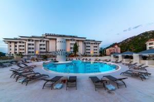 a large pool with chairs and a building at Faros Premium Beach in Marmaris