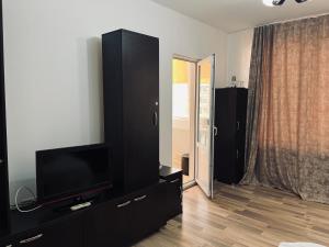 uma sala de estar com um centro de entretenimento preto com uma televisão de ecrã plano em Apartament de lux em Costinesti