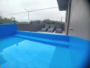 uma vista para uma piscina azul com 2 cadeiras em 海灣旅宿 em Sanzhi