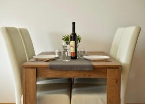 a wooden table with a bottle of wine on it at Sofija in Ulcinj +7 photos