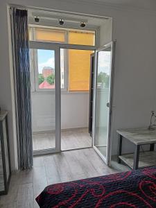 een slaapkamer met een glazen schuifdeur en een raam bij Home in Center with jacuzzi in Ivano-Frankivsʼk