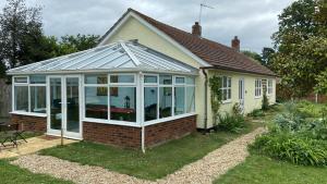 a conservatory with a glass roof on a house at Greengates of Shouldham in Shouldham