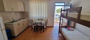 a small kitchen with a table and a bunk bed at Roan Apartments in Velipojë