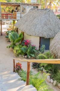 Cabaña pequeña con techo de paja y algunas plantas en Casa Mate BeachFront Cabañas El Cuyo, en El Cuyo