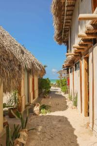 un vicolo tra due edifici con l'oceano sullo sfondo di Casa Mate BeachFront Cabañas El Cuyo a El Cuyo
