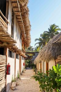 an alley between two buildings with thatched roofs at Casa Mate BeachFront Cabañas El Cuyo in El Cuyo
