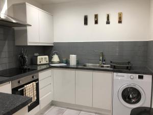 a kitchen with white cabinets and a washing machine at 08 St Andrews in Lytham St Annes