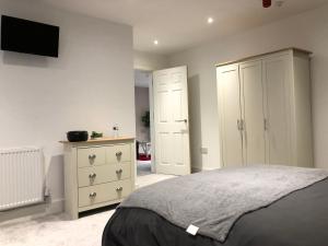 a bedroom with a bed and a dresser and a tv at 08 St Andrews in Lytham St Annes