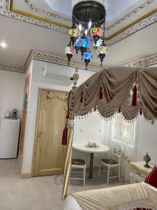 a bedroom with a bed and a table and a ceiling at Chambre Orientale Chérazade Maison de L'Église in Narbonne