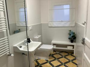 a white bathroom with a toilet and a sink at CAL GUINEU in Vallfogona de Balaguer