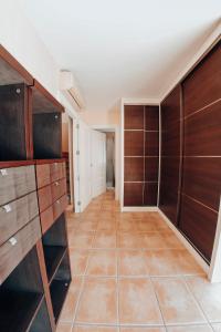 a room with wooden cabinets and a tiled floor at Casa adosada con piscina privada in Alfaz del Pi