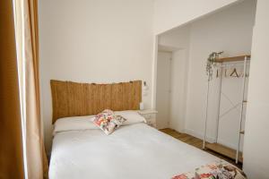 een slaapkamer met een wit bed met een kussen erop bij Da Fede in Rome