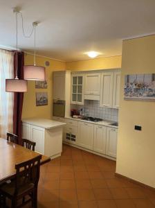 a kitchen with white cabinets and a table and a dining room at La Terrazza in Spoleto