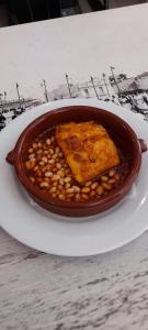 a bowl of food on a plate on a table at Hostal Vila del Mar in Lloret de Mar