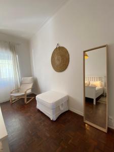 a white room with a mirror and a bed at Flora's Lisbon in Lisbon
