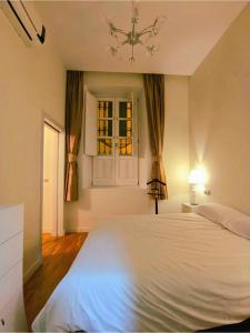 um quarto com uma cama branca e uma janela em Apartamento Spinola Home em Sevilha