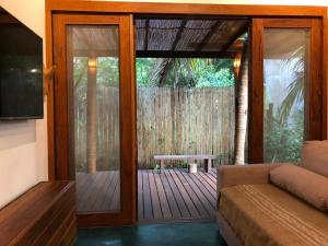 a living room with a sliding glass door with a bench at HaraMatha in Barra Grande