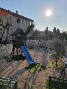 a playground with a slide and a swing at Villa Karla in Jadranovo