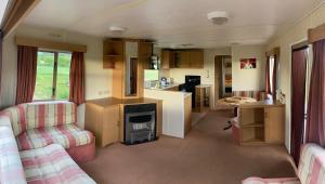 a living room with a couch and a stove in a caravan at Nature&Rest in Łąck