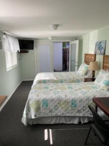 a bedroom with two beds and a table and a desk at Glendale Guest House in Glendale
