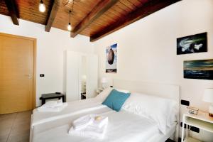 - une chambre avec un lit blanc et un plafond en bois dans l'établissement Il sogno del pescatore, à Scilla