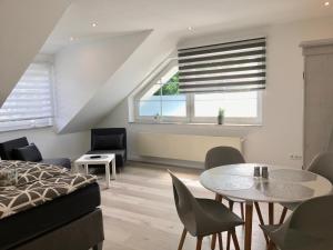 a bedroom with a bed and a table and chairs at H&E Apartments in Steinheim