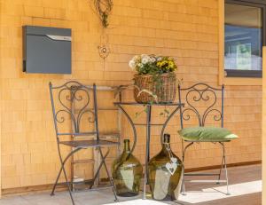 dos sillas y una mesa con dos botellas de vino en Haus Amatschon en Brand