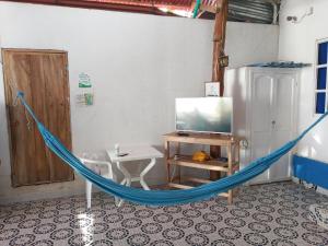 a hammock in a room with a tv and a table at Gran Muelle Hotel in San Bernardo del Viento