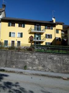 a yellow building on the side of a street at Le tue vacanze a Varzo, appartamento il girasole. in Varzo