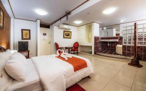 a bedroom with a bed and a living room at Recreo Hotel in Trujillo