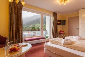 a hotel room with a bed and a large window at Familotel Bavaria Pfronten-Familien Hotel-Alles Inklusive Konzept in Pfronten