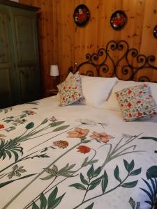 a bed with a floral bedspread and pillows on it at Sella Ronda Apartment in Campitello di Fassa