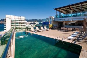 a swimming pool with lounge chairs and a building at Arena Ipanema Hotel in Rio de Janeiro
