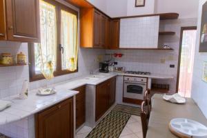 una cucina con armadi in legno e piano cottura. di Villa Tonia a Fasano