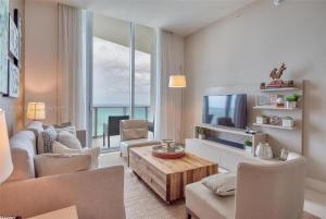 a living room with a couch and a tv at Penthouse Condo at Lyfe Resort and Residences in Hollywood