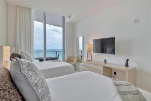 a hotel room with two beds and a television at Penthouse Condo at Lyfe Resort and Residences in Hollywood +22 photos