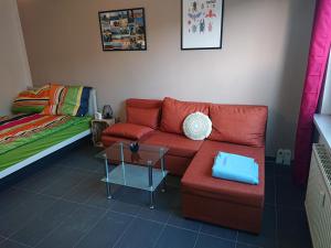 un soggiorno con divano rosso e letto di FeWo Leipziger Neuseenland a Neukieritzsch