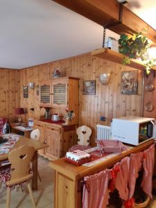 a kitchen with wooden walls and a table with a microwave at Sella Ronda Apartment in Campitello di Fassa