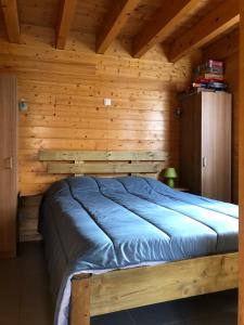 ein Schlafzimmer mit einem Bett in einer Holzhütte in der Unterkunft Chalet exposition plein sud in Xonrupt-Longemer