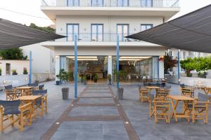 a patio with tables and chairs and a building at Vivari Acta in Vivari