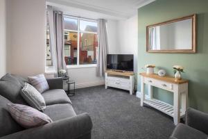 a living room with a couch and a television at Family friendly 2-bedroom home in Blackpool in Blackpool