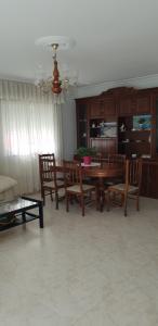 a living room with a wooden table and chairs at Emilia Primero in Lariño