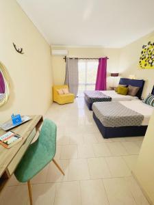 a room with two beds and a table and a chair at Avra Sunset Sea View Liapades in Liapades +166 photos