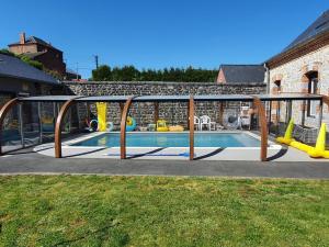 een zwembad met een metalen frame eromheen bij Duplex Swimming Cats in Saint-Hilaire-sur-Helpe