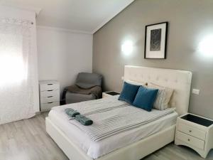 a bedroom with a large white bed with blue pillows at Sunshine Beach Apartments in Adeje