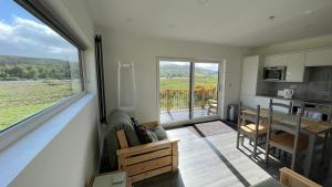 a kitchen and dining room with a large window at Ceol Mor Highland Lodges in Lairg