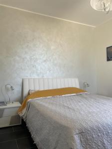a white bedroom with a bed and a wall at Capovaticano - Unique SEA VIEW - Villa Renaissance in Santa Maria